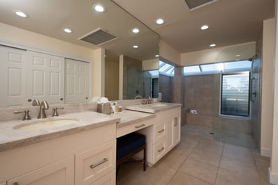 Relax and unwind in this elegant bathroom featuring a deep soaking tub, dual vanity, and soft natural lighting