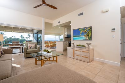 Natural light flows through wide glass doors, creating a seamless indoor-outdoor island experience