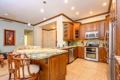 Elegant kitchen with granite countertops, stainless appliances, and warm cabinetry. KGV-16P3