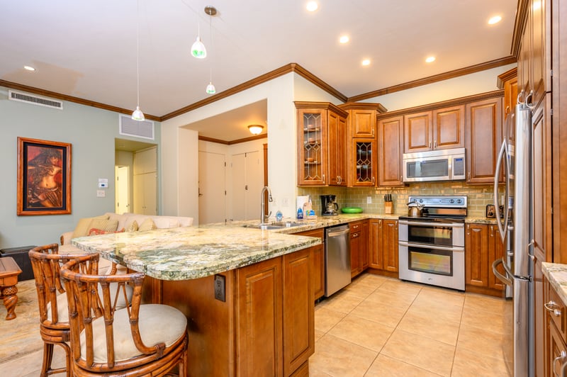 Elegant kitchen with granite countertops, stainless appliances, and warm cabinetry. KGV-16P3