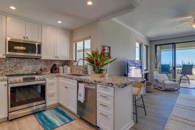 Start your mornings barefoot on cool tile, brewing coffee in this coastal kitchen while sunlight filters through the palms outside KGV-17T5