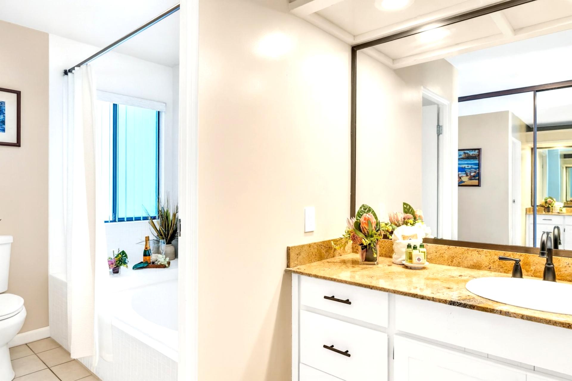 Beautiful vanity and well-lit mirrors create a convenient and comfortable primary bathroom setup.