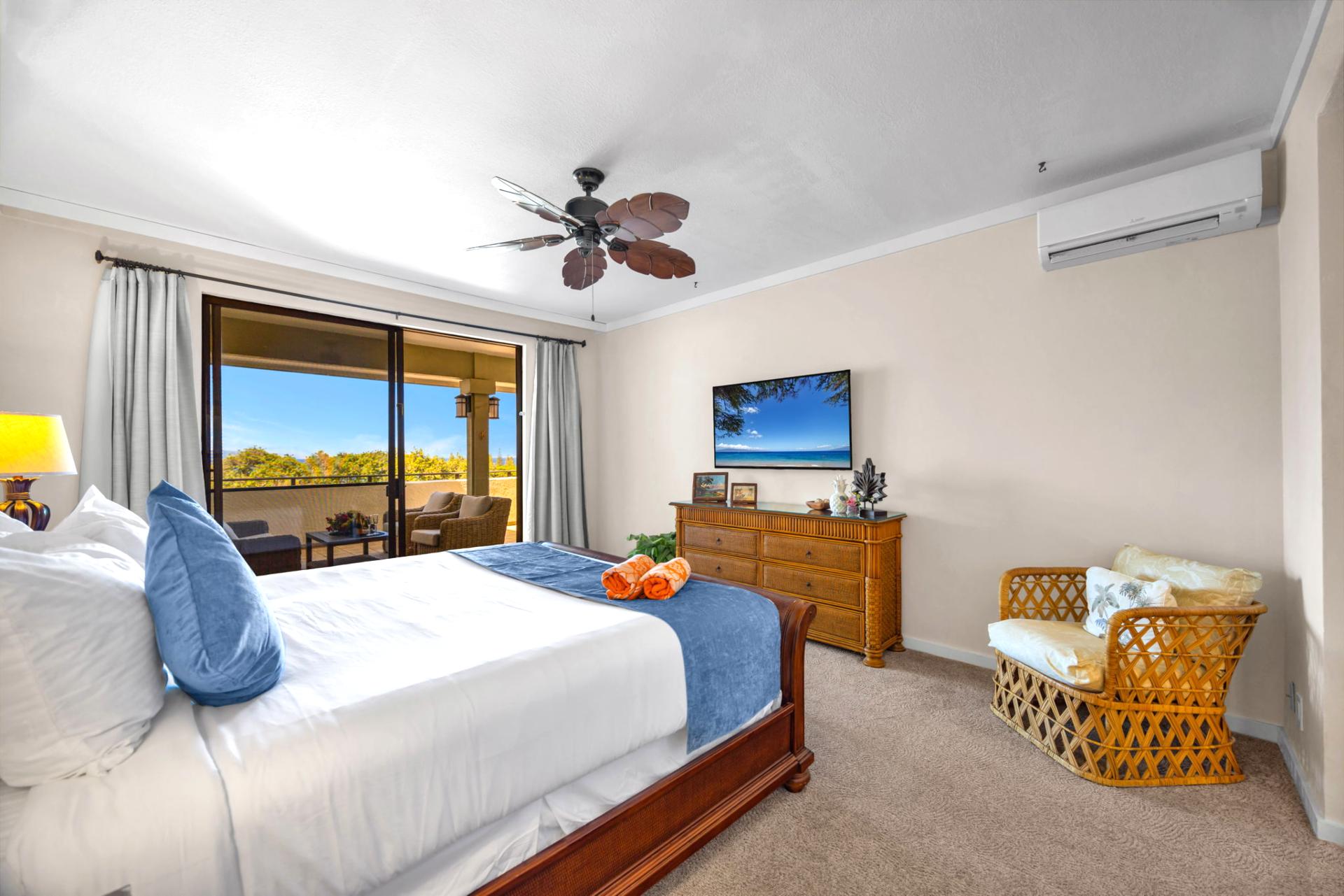 Wake to lush resort views in this serene King bedroom with breezy ceiling fan and clean design.