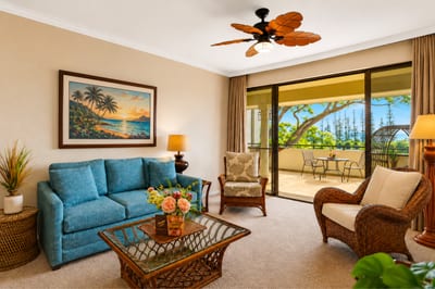 The open-concept living area features a ceiling fan, comfortable seating, and views that carry the outdoors in.