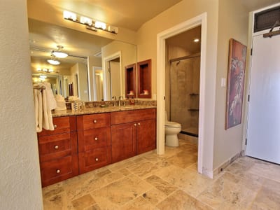 Begin your day with a mirror-lit smile and end it in soothing stone and warm wood—this bathroom completes the story of rest