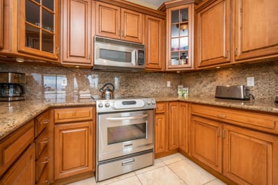 This warm, wood-accented kitchen offers granite countertops, stainless appliances, and seamless flow into the dining area