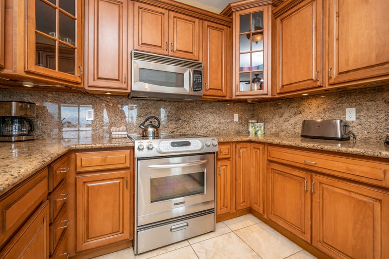 This warm, wood-accented kitchen offers granite countertops, stainless appliances, and seamless flow into the dining area