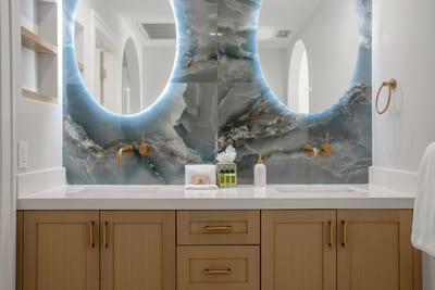 From the radiant mirrors to the glistening sea-tile walls, every detail in this guest bath is a treat for the senses