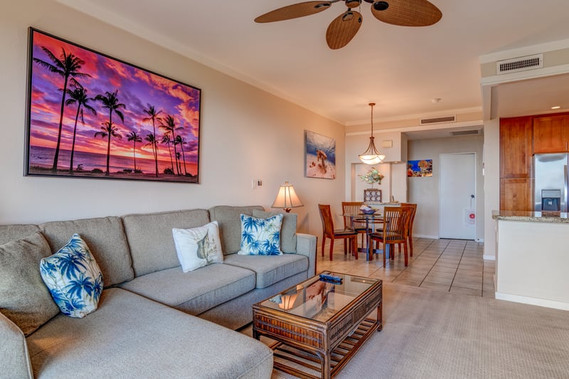 Spacious tropical condo with sunset art, island decor, and dining.