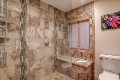 With its frameless shower, granite surfaces, and modern comforts, this guest bathroom is both functional and refreshingly luxurious