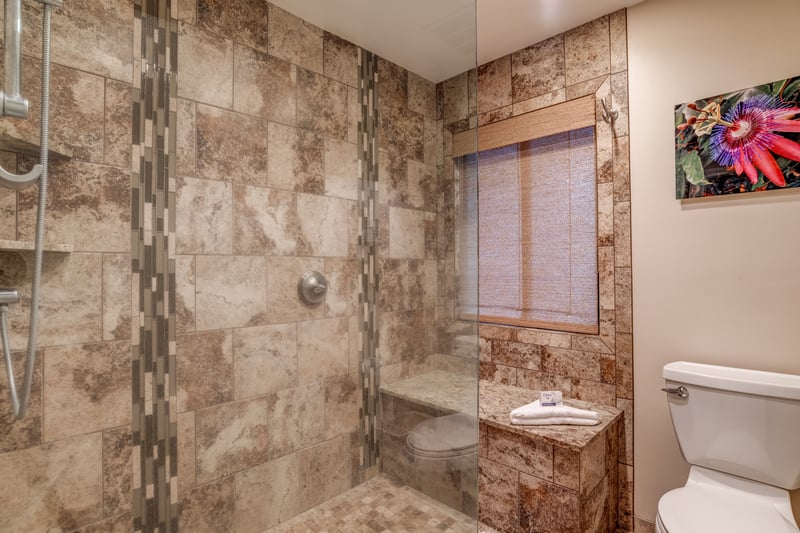 With its frameless shower, granite surfaces, and modern comforts, this guest bathroom is both functional and refreshingly luxurious
