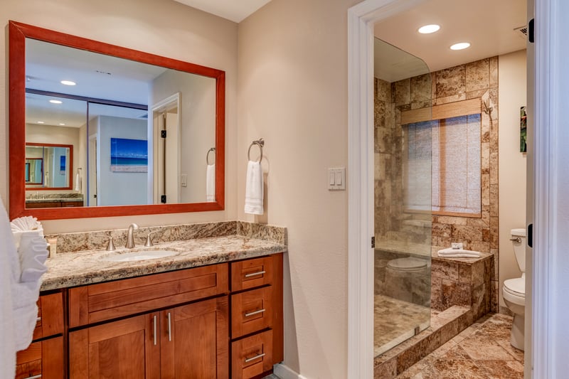 A bright and beautifully appointed guest bath, featuring a pebble-tiled shower, modern fixtures, and soothing tones to refresh your stay