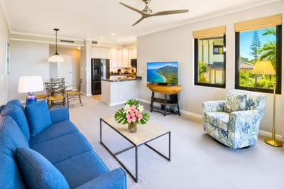Open-concept living with a comfortable sectional, flat-screen TV, and a straight sightline through to the kitchen.