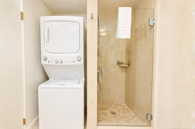 In-unit stacked washer and dryer make it easy to pack light, right next to the second bathroom's walk-in shower.