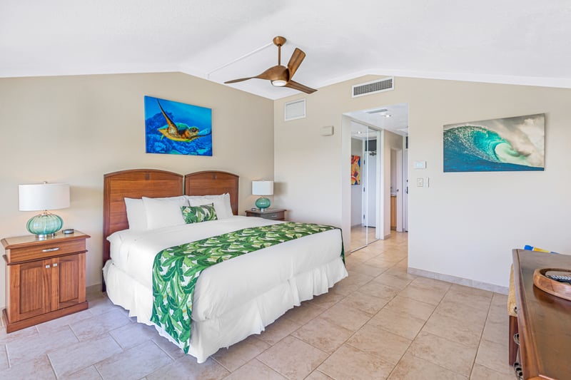 Cozy coastal bedroom with ocean art and tropical green accents.