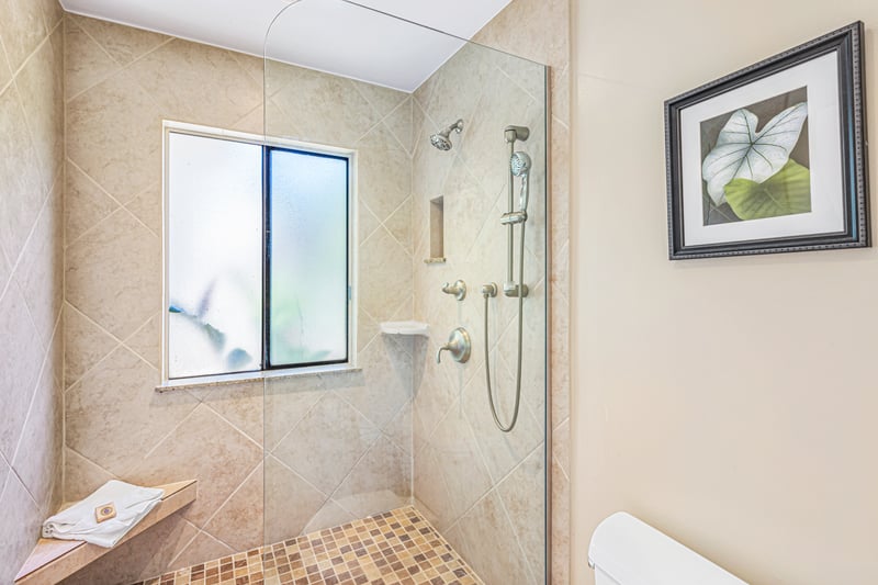 With its frameless shower, granite surfaces, and modern comforts, this guest bathroom is both functional and refreshingly luxurious