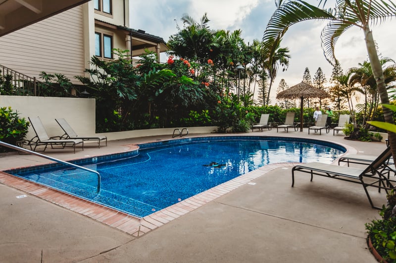 Unwind in the tropical elegance of the Kapalua Golf Villas' serene pool area—surrounded by lush gardens, swaying palms, and island breezes    