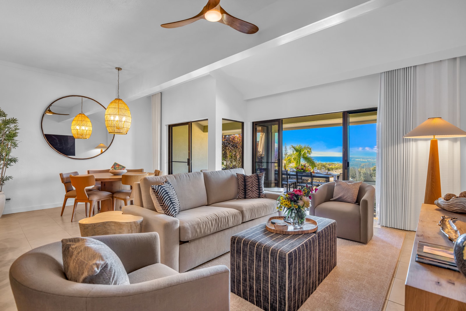 Lounge in the spacious living room with soft seating and wide lanai doors bringing the outdoors in. KGV-24P7