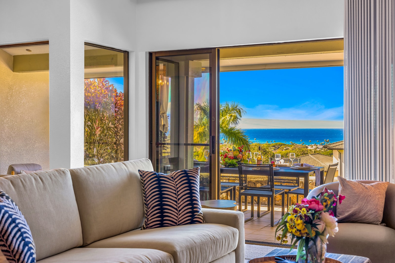 The living space offers comfortable seating and seamless access to outdoor dining on the lanai. KGV-24P7