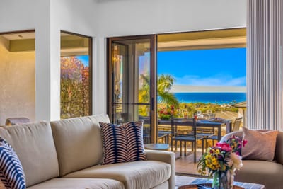 The living space offers comfortable seating and seamless access to outdoor dining on the lanai. KGV-24P7