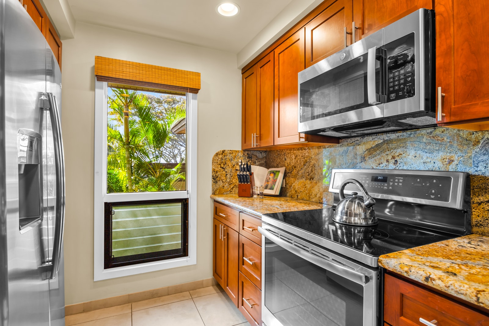 The kitchen features warm wood cabinetry and granite counters