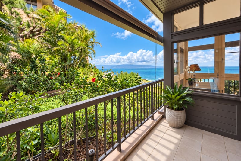 Private lanai framed by tropical garden greenery, offering an unobstructed Pacific Ocean and Molokai horizon view.
