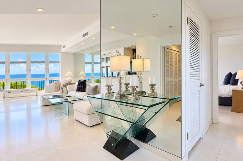 Elegant entry vignette with a glass console table, setting an inviting tone just steps from the ocean view living room.