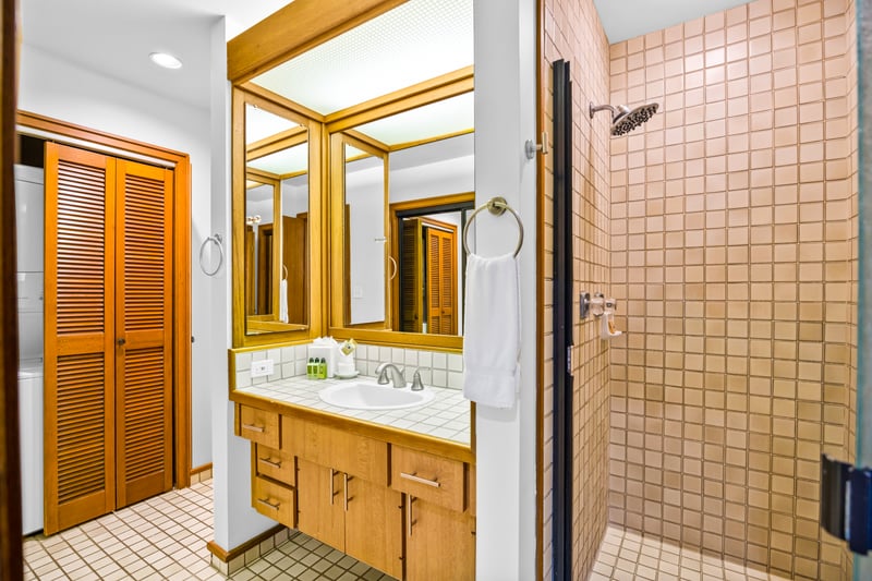 The primary bath features a walk-in shower and warm wood tones for a spa-like refresh.