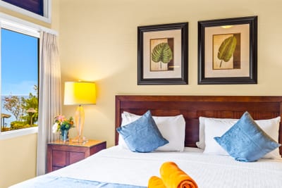 The spacious bedroom includes a King bed, wood furnishings, and soft bedside lighting.