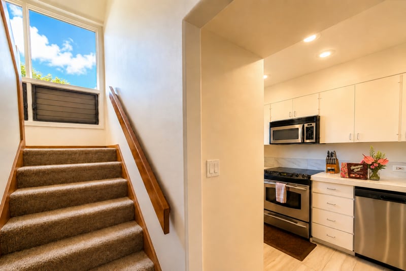 Interior staircase leading up past the full kitchen