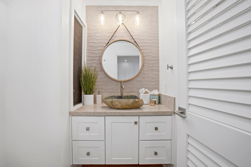 Floating mirrors suspended from the ceiling make a bold statement while maximizing the room’s airy feel   