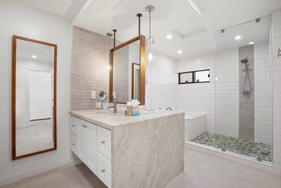The double vanity with a polished marble surface and bronze-accented mirrors offers both style and functionality KRV-2823