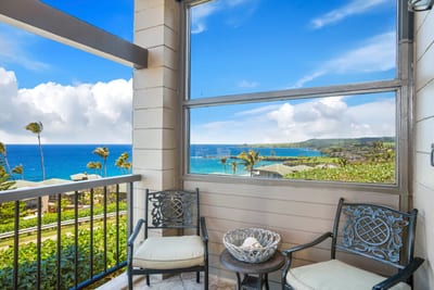 Cozy balcony seating with breathtaking ocean and lush coastline views.