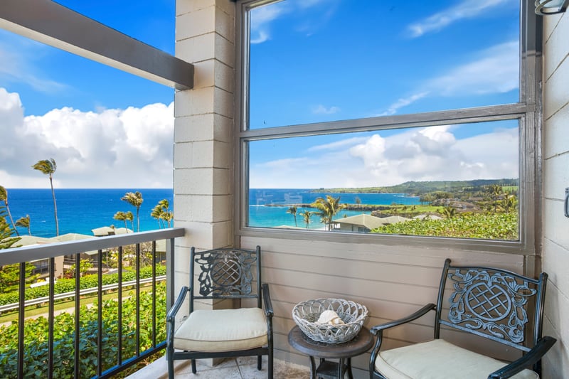 Cozy balcony seating with breathtaking ocean and lush coastline views.