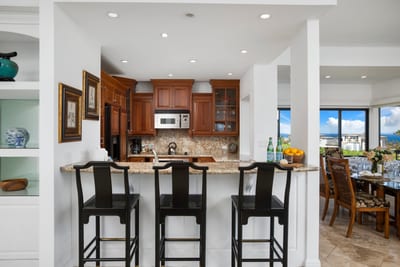Inviting kitchen bar opens to ocean-view dining experience nearby.