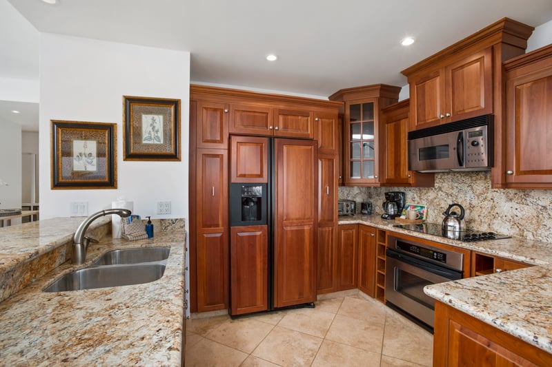 Warm wood cabinetry and granite surfaces define this elegant kitchen.
