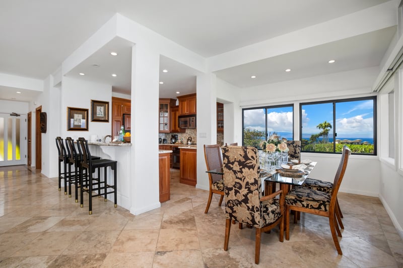 Chic open-concept dining and kitchen with lush oceanview backdrop.
