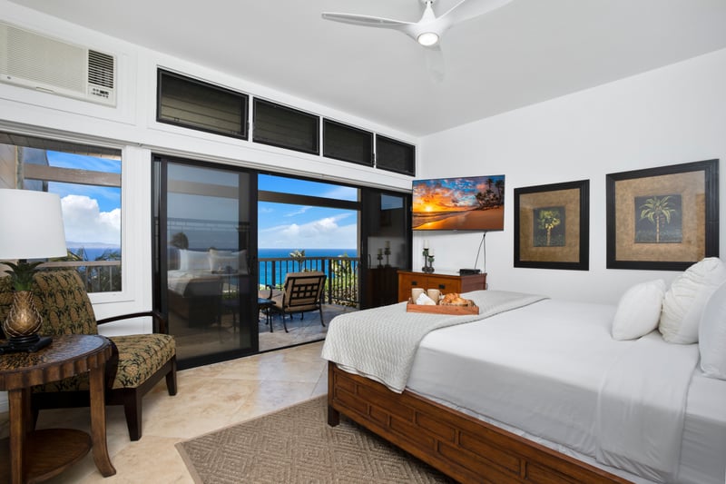 Serene bedroom retreat with balcony and breathtaking oceanfront views.