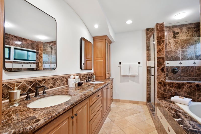 Double vanity and marble finishes enhance this spa-like bathroom retreat.