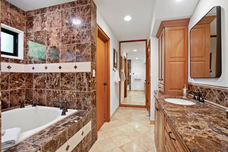 Luxurious bathroom with marble finishes, soaking tub, and double vanity.