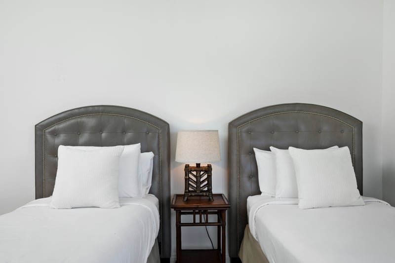 Tailored headboards, framed art, and the glow of island light create a space as graceful as it is restful