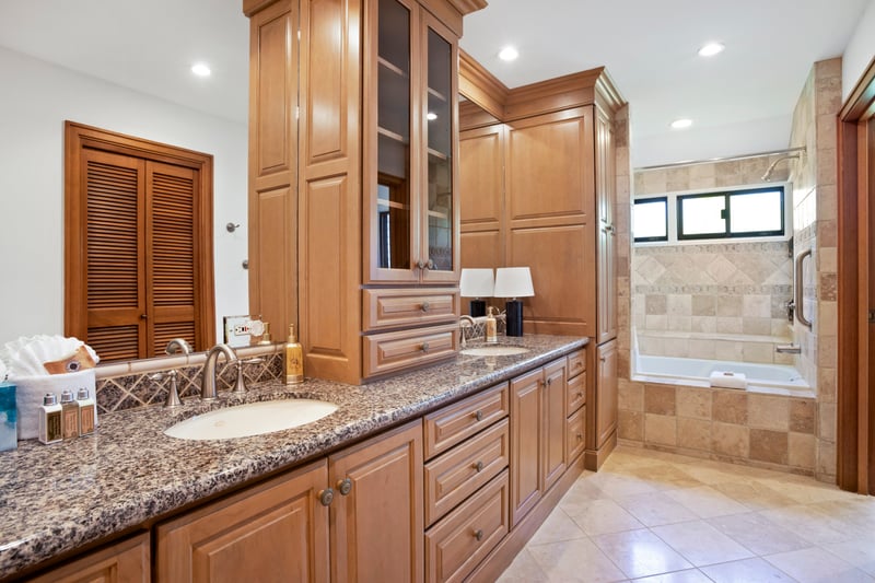 Spacious luxury bathroom with double vanity, granite counters, and tub.