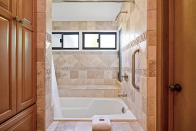 Luxurious tiled bathtub with window lighting and built-in bench seating.