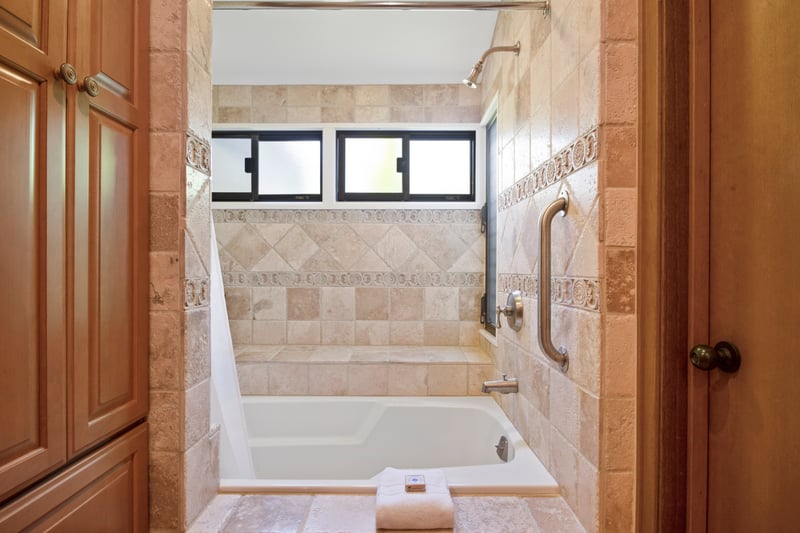 Luxurious tiled bathtub with window lighting and built-in bench seating.