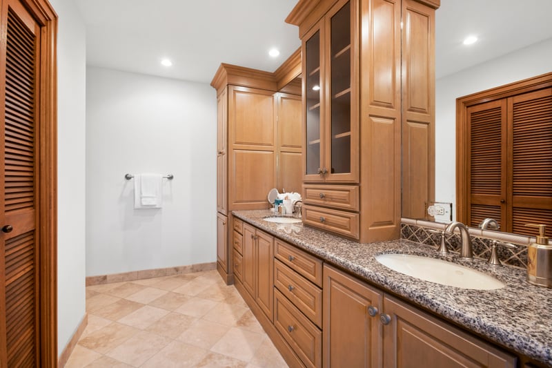 Elegant double vanity bathroom with granite countertop and wood cabinetry.