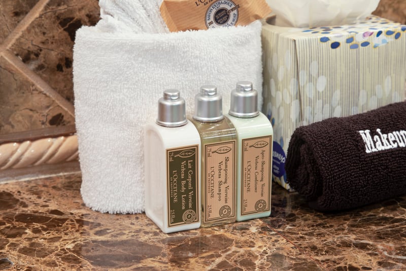 Luxury L’Occitane toiletries and plush towels on marble bathroom counter.