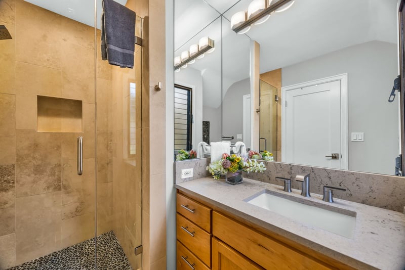 The guest bath features a glass, walk in shower