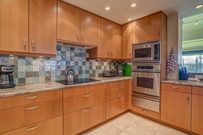 Channel your inner chef in this sparkling wood-toned kitchen with mosaic tile magic and glimmering granite KRV-722