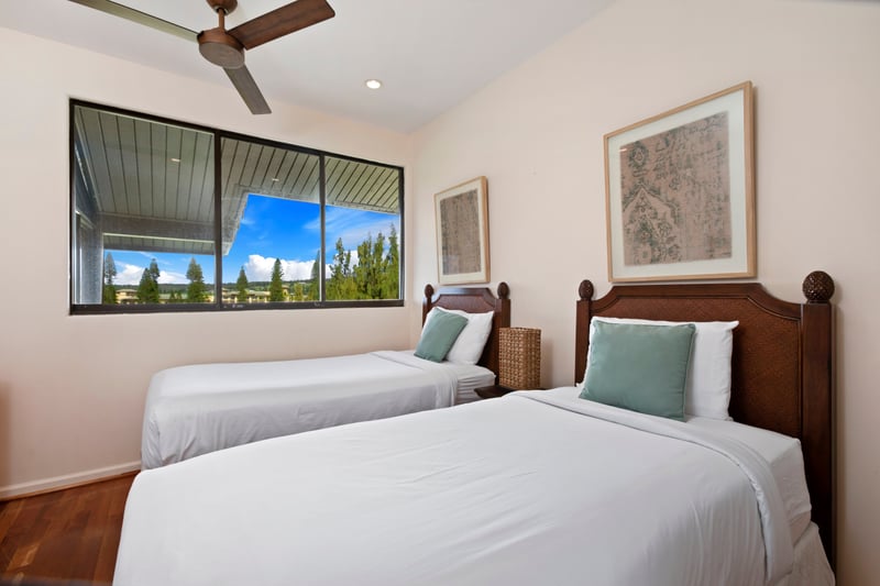 Sleep in style beneath modern fans and vintage-inspired art, with views that open wide to the blue Hawaiian sky KRV-722
