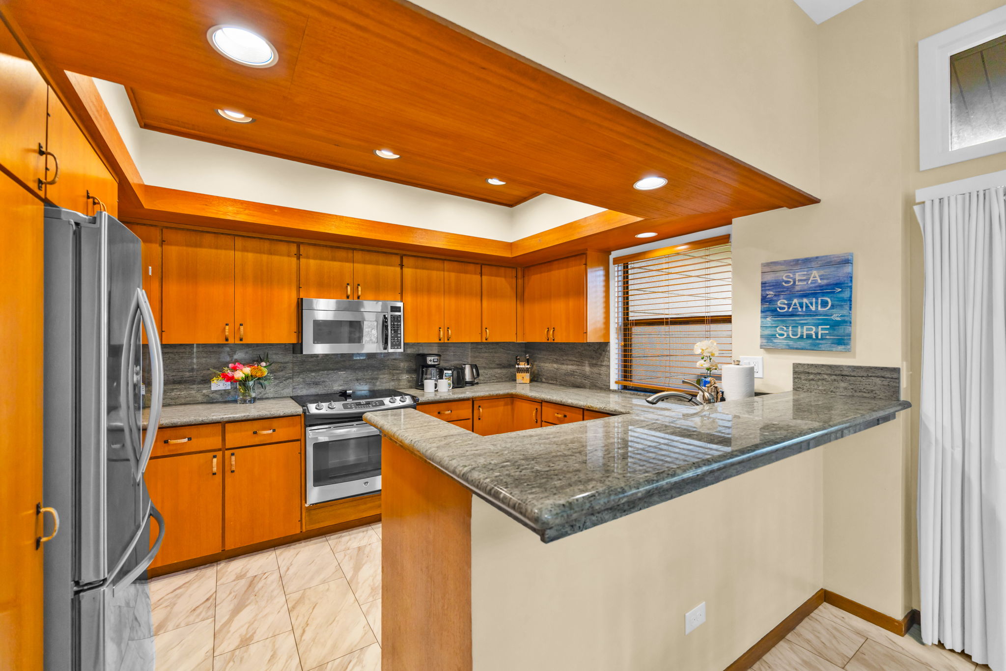 Fully equipped kitchen with bar seating and rich wood cabinetry.